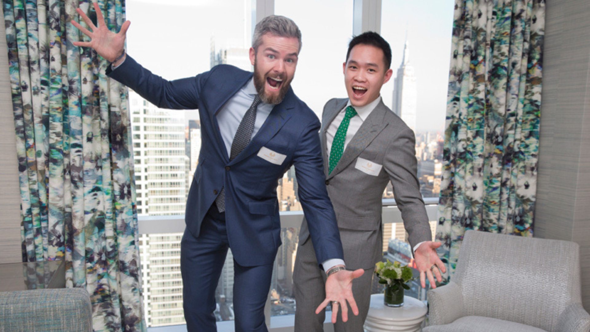 Ryan Serhant (left) and Chester Yow (right) standing together, both in professional attire, smiling confidently.