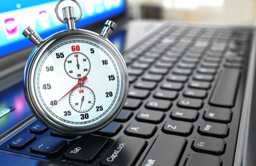 Stopwatch on laptop keyboard. Deadline concept.